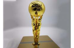China Shiny Gold Plated Custom Trophy Cup With The Statue Holding The Ball Design supplier