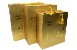 China Custom Luxury Printed Gold Paper Gift Bags With Embossed Logo Tassel Handles supplier
